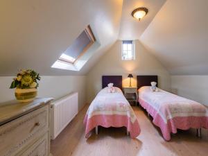 - une chambre mansardée avec 2 lits et une fenêtre dans l'établissement Inviting holiday home in Nieuwpoort with private garden, à Nieuport