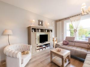 a living room with a couch and a tv at Inviting holiday home in Nieuwpoort with private garden in Nieuwpoort