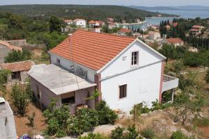 une maison blanche avec un toit rouge sur une colline dans l'établissement Apartments with a parking space Zman, Dugi otok - 449, à Žman