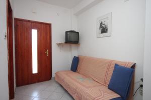 - un salon avec un canapé et une télévision dans l'établissement Apartments with a parking space Zman, Dugi otok - 449, à Žman