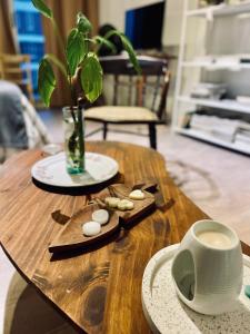 una mesa de madera con una taza de café y un jarrón en Delicado loft amplio y de diseño en Rosario