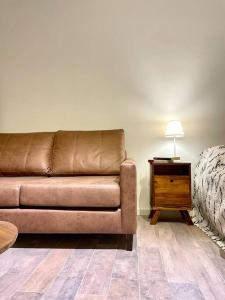 a brown couch sitting in a living room with a table at Delicado loft amplio y de diseño in Rosario