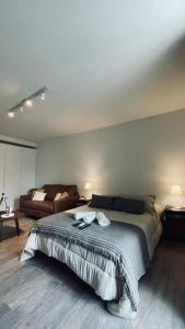 a bedroom with a large bed and a couch at Delicado loft amplio y de diseño in Rosario