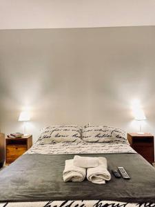 a bed with two towels and two remotes on it at Delicado loft amplio y de diseño in Rosario