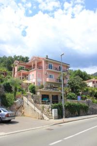 a pink building on the side of a road at Double Room Medveja 2305a in Lovran