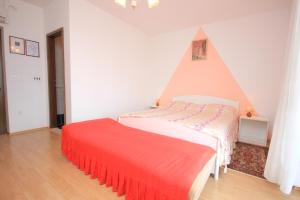 a bedroom with a bed and a red bedspread at Double Room Medveja 2305a in Lovran