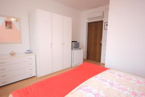 a bedroom with white cabinets and a bed with a red blanket at Double Room Medveja 2305a in Lovran