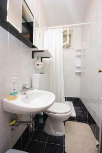 La salle de bains blanche est pourvue d'un lavabo et de toilettes. dans l'établissement Double Room Medveja 2305a, à Lovran