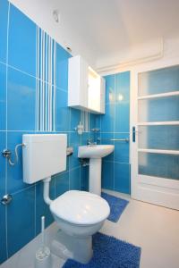 Baño azul con aseo y lavamanos en Apartments and rooms by the sea Medveja, Opatija - 2305 en Lovran