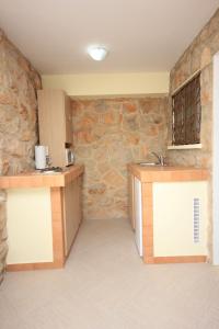 een keuken met een wastafel en een stenen muur bij Apartments and rooms by the sea Medveja, Opatija - 2305 in Lovran