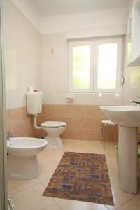 een badkamer met 2 toiletten en een wastafel bij Apartment Moscenicka Draga 2327c in Mošćenička Draga