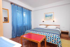 a bedroom with a bed and a red table at Apartments by the sea Mali Losinj (Losinj) - 2485 in Mali Lošinj