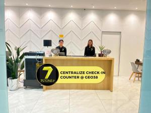 two people standing behind a counter with a sign at 7Stonez Residences Midhills Genting Highlands in Genting Highlands