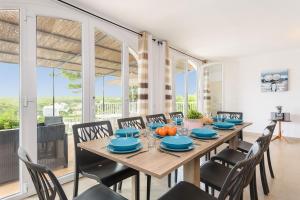 uma sala de jantar com uma mesa de madeira e cadeiras em Villa Pinar by Villa Plus em Ferreries