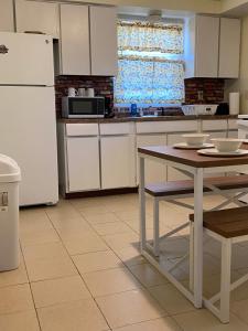 a kitchen with a table and a white refrigerator at Spacious 3bedroom free wine,WiFi,and parking in Milwaukee