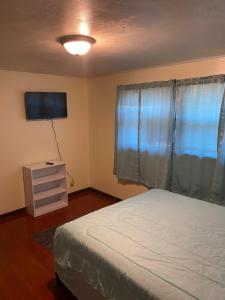 a bedroom with a bed and a dresser and a television at Spacious 3bedroom free wine,WiFi,and parking in Milwaukee