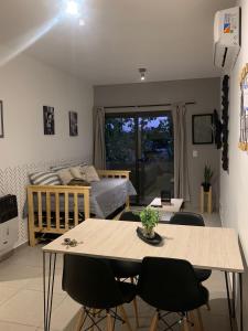 uma sala de estar com uma cama, uma mesa e cadeiras em Pellegrini Apartment Mendoza em Mendoza