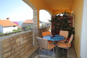 eine Terrasse mit einem Tisch und Stühlen auf dem Balkon in der Unterkunft Apartments with a parking space Preko, Ugljan - 8428 in Preko