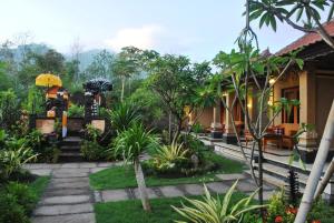 a garden in front of a house at Trijaya Guest House Pemuteran in Pemuteran