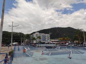 un skatepark avec des gens dans un skatepark dans l'établissement Apartamento Avenida da Praia Centro Caraguatatuba, à Caraguatatuba