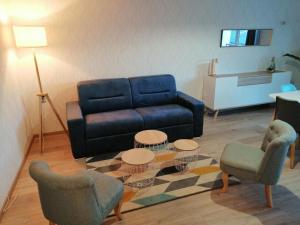 een woonkamer met een blauwe bank en 2 stoelen bij Beautiful apartment by the harbor in Port-en-Bessin-Huppain in Port-en-Bessin-Huppain