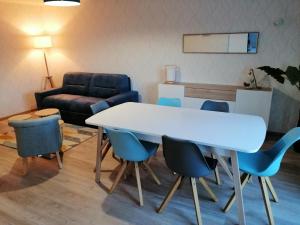 een kamer met een tafel en stoelen en een bank bij Beautiful apartment by the harbor in Port-en-Bessin-Huppain in Port-en-Bessin-Huppain