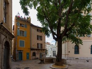 a tree in front of a building with a clock tower at Elegant holiday home with pool in Toulon