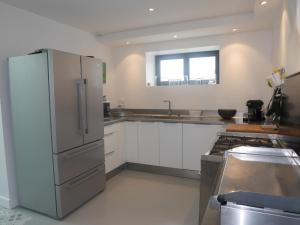 eine Küche mit einem Kühlschrank aus Edelstahl und einer Spüle in der Unterkunft Beachfront Holiday Home, Penmarch-St Guénolé in Penmarcʼh