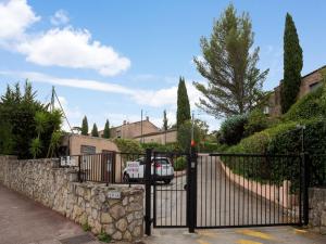 Ein schwarzer Zaun mit einem Auto, das in einer Einfahrt parkt. in der Unterkunft Elegant holiday home with pool in Toulon