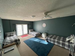 a room with two beds and a ceiling fan at Hakuna Matata Hostel Shared Room in Charlotte