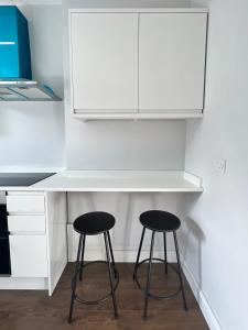 two stools sitting under a counter in a kitchen at Dunstable Boutique Guest House in Dunstable