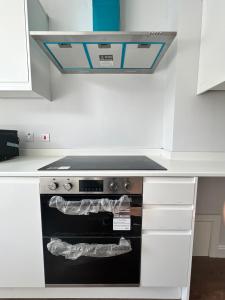 a stove top oven in a white kitchen at Dunstable Boutique Guest House in Dunstable