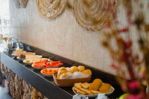 a buffet line with different types of food on plates at Velho Chico in Icaraí