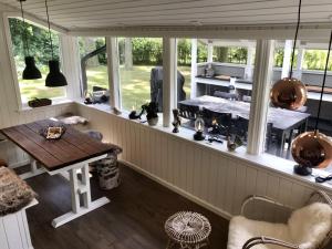 een kamer met een tafel en een aantal ramen bij Nordic Relax House - Stonehouse in Sjöbo