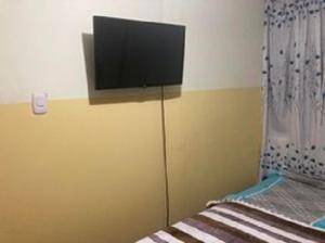 a flat screen tv on the corner of a bedroom at ZAKAED HOME Airport in Lima