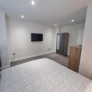 a bedroom with a bed and a flat screen tv at 4 bed apartment In Enfield north London in Enfield Lock
