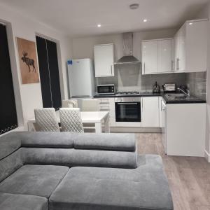 ein Wohnzimmer mit einem Sofa und einer Küche in der Unterkunft 4 bed apartment In Enfield north London in Enfield Lock