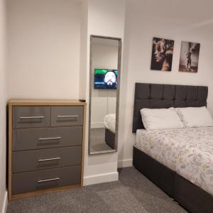 - une chambre avec une commode et un miroir dans l'établissement 4 bed apartment In Enfield north London, à Enfield Lock