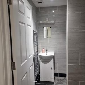ein Bad mit einem Waschbecken und einer Dusche in der Unterkunft 4 bed apartment In Enfield north London in Enfield Lock