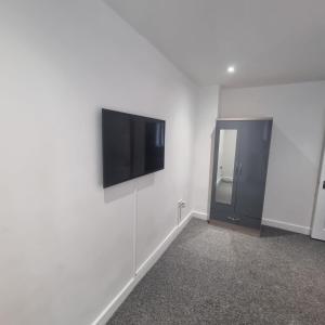 a room with a flat screen tv on a wall at 4 bed apartment In Enfield north London in Enfield Lock