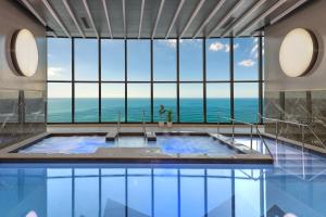 a large swimming pool with a view of the ocean at Meriton Suites Surfers Paradise in Gold Coast