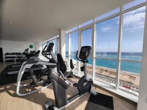 a gym with cardio machines and a large window at ARUBA DREAM GETAWAY 2BR/2BT OCEAN & POOL VIEW in Oranjestad