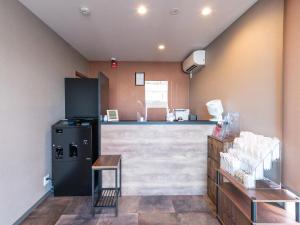 a kitchen with a black refrigerator and a counter at HOTEL R9 The Yard Ishioka in Ishioka