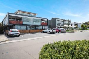 a parking lot with cars parked in front of a building at The Bay Townhouse 500m to beach 15min to CBD in Hobart