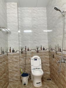 een badkamer met een toilet en een douche bij Mi Casa Homestay in Da Lat