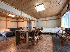 a room with a table and chairs and a bed at 草津温泉 湯之風 in Kusatsu