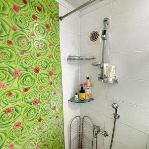 uma casa de banho com uma cortina de chuveiro verde com rosas em Memory - Internationals Only em Daegu