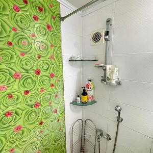 a bathroom with a green shower curtain with roses on it at Memory - Internationals Only in Daegu