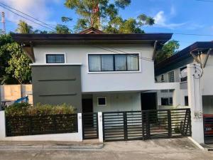 una casa blanca con una valla negra en Modern House w/Great Location Nr SM & Jack’s Ridge, en Davao City