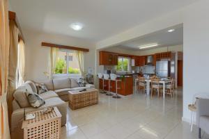 a living room with a couch and a kitchen at Villa Savia by Villa Plus in Peyia